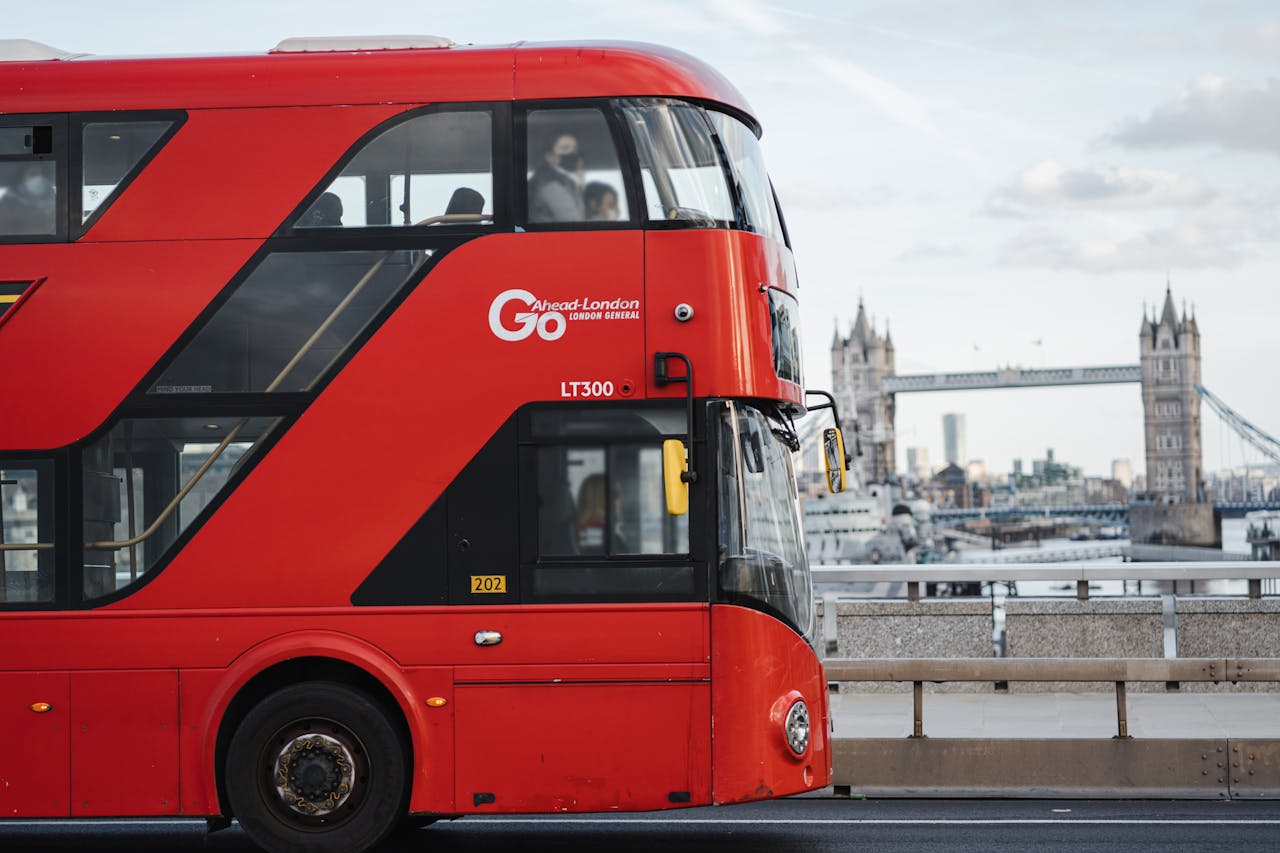 Classic London red double-decker bus crossing with historic Tower Bridge in the background.